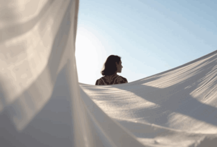 Femme de dos et voiles blancs sur fond de ciel bleu