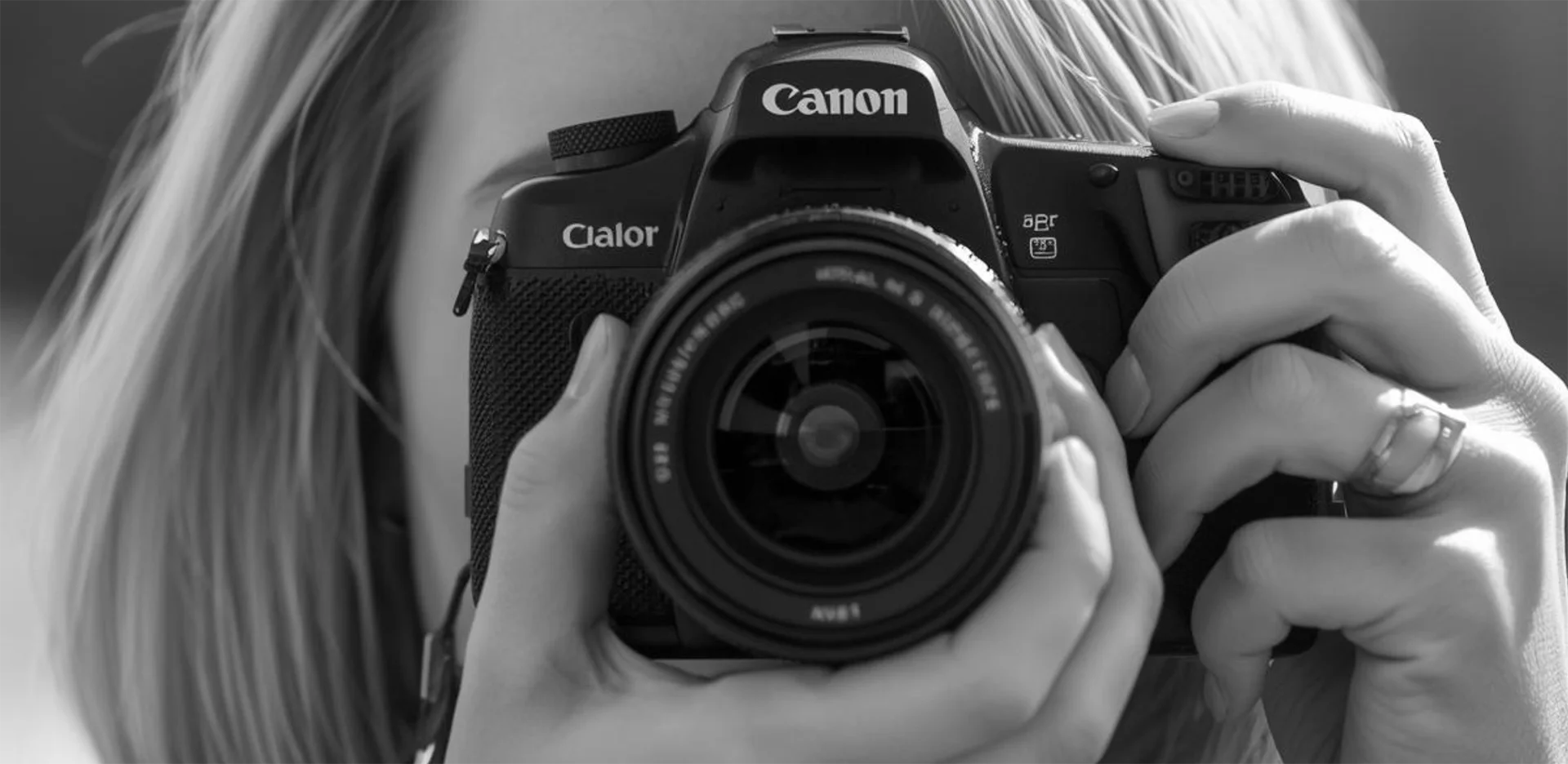 Gros plan en noir et blanc d'une femme avec un appareil photo