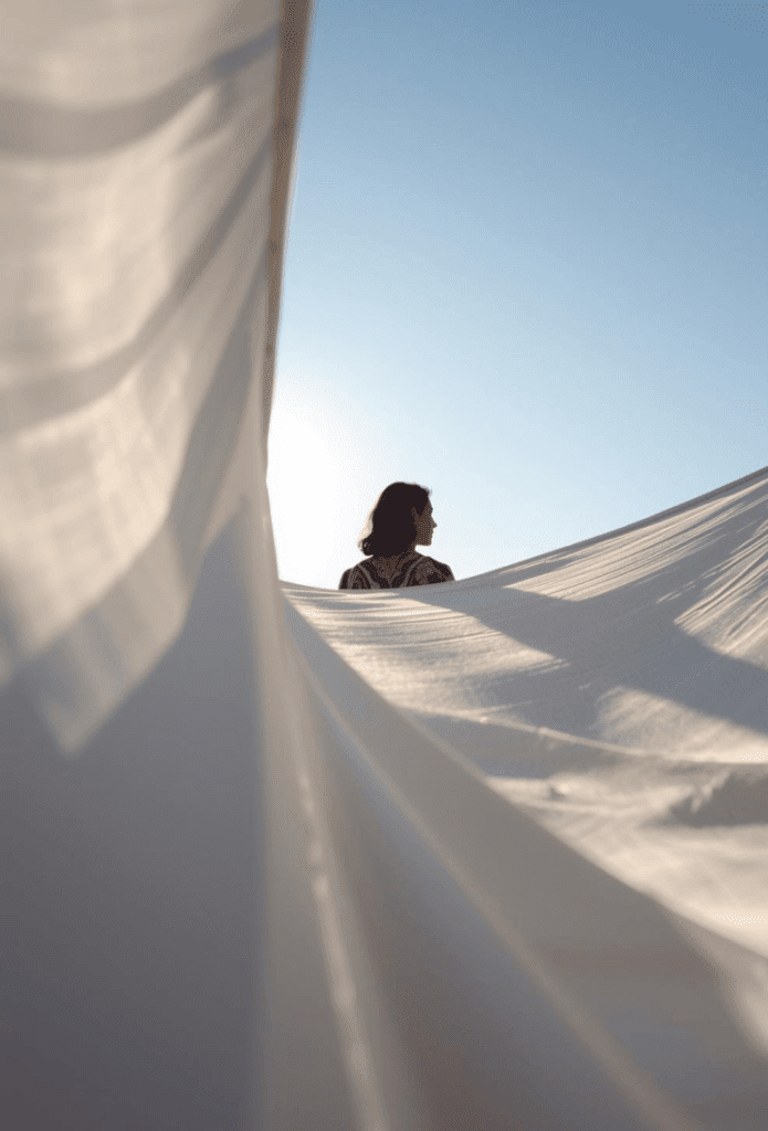 Femme de dos et voiles blancs sur fond de ciel bleu
